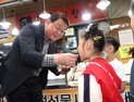 [포토] 전통시장서 어린이에게 떡 먹여주는 박성효 소진공이사장 