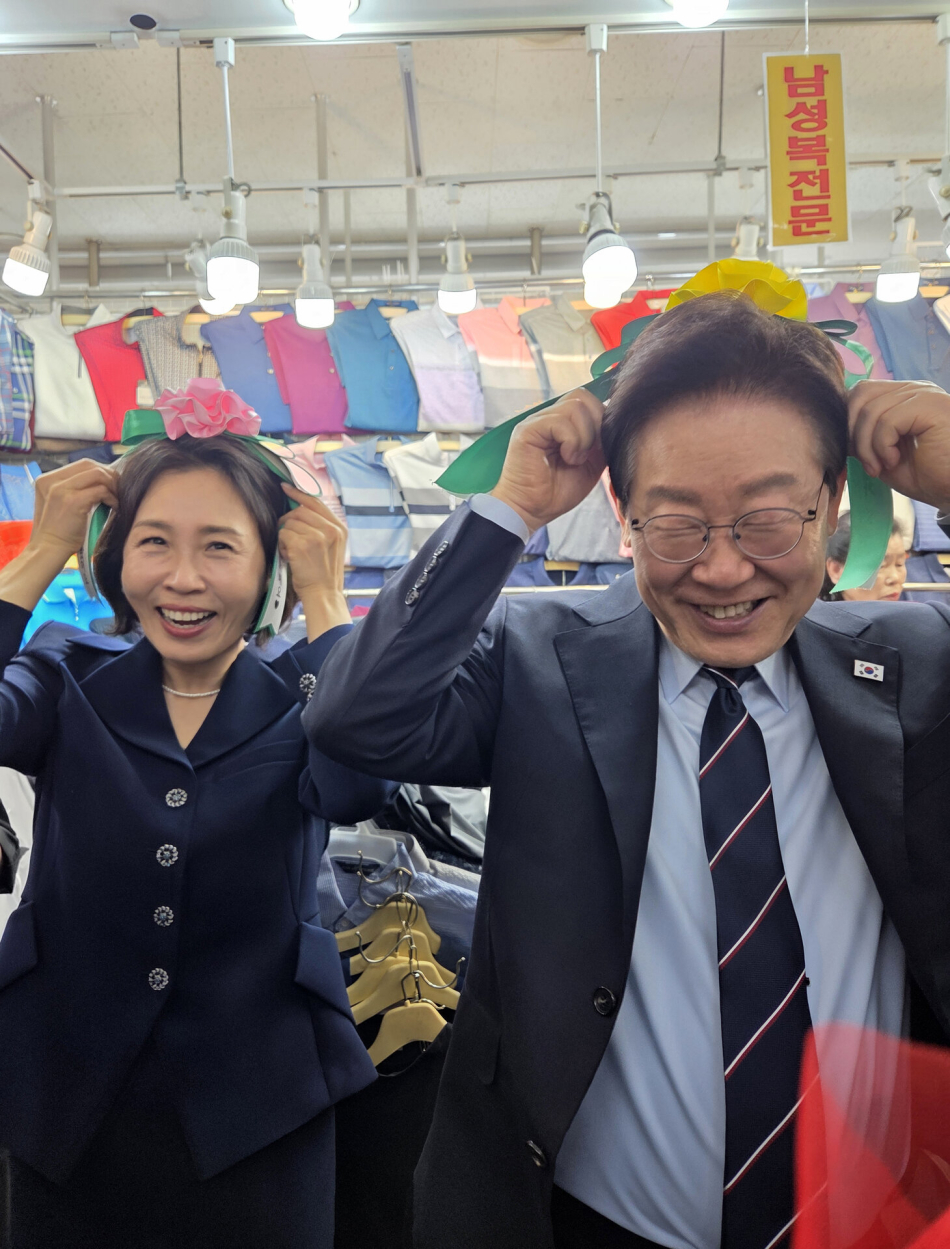 이재명 대통령과 김혜경 여사가 8일 서울 남대문시장 한 상점에서 카네이션 머리띠를 착용해 보고 있다. 연합뉴스