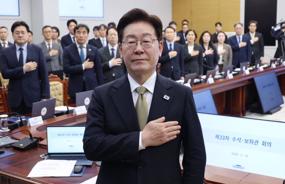 이재명 대통령이 지난 14일 청와대에서 열린 수석보좌관회의에서 국기에 경례하고 있다. 연합뉴스