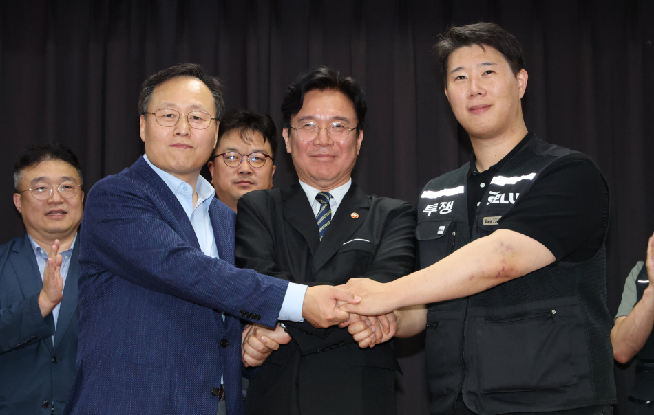 (왼쪽에서 첫번째)여명구 삼성전자 DS(디바이스솔루션·반도체 사업 담당) 피플팀장과 (왼쪽에서 세번째)최승호 삼성그룹 초기업노동조합 삼성전자지부 위원장이 20일 경기도 수원시 장안구 경기고용노동청에서 열린 삼성전자 임금협상을 마친 후 잠정 합의안에 서명한 후 김영환 고용노동부 장관과 손을 맞잡고 있다. 연합뉴스