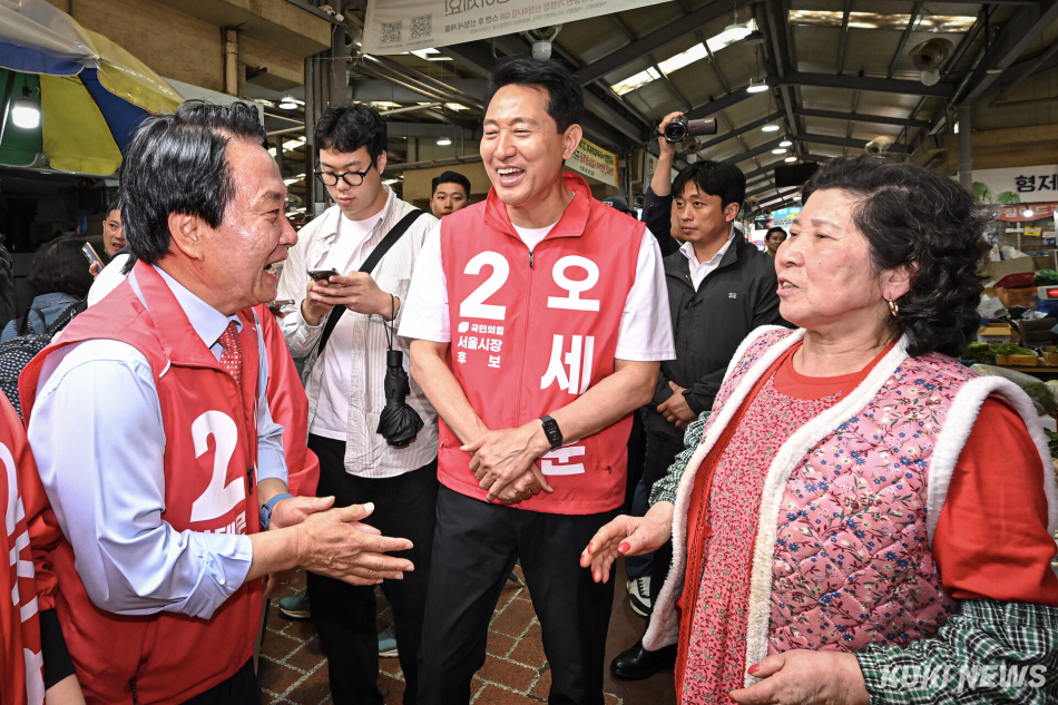 오세훈(가운데) 국민의힘 서울시장 후보와 이성헌 국민의힘 서대문구청장 후보가 21일 서울 서대문구 인왕시장에서 상인과 대화하고 있다.