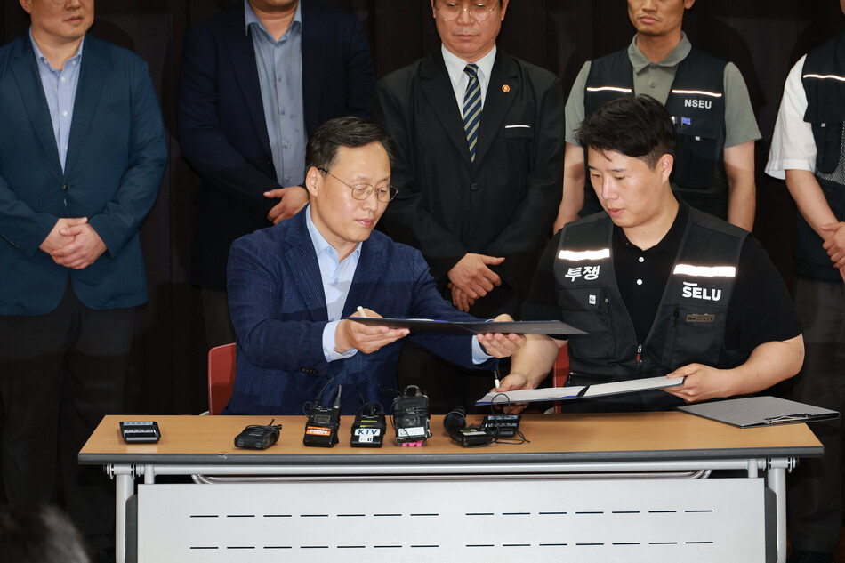 20일 경기도 수원시 장안구 경기고용노동청에서 열린 삼성전자 임금협상을 마친 후 여명구 삼성전자 DS(디바이스솔루션·반도체 사업 담당) 피플팀장과 최승호 삼성그룹 초기업노동조합 삼성전자지부 위원장이 잠정 합의안에 서명하고 있다. 공동취재단