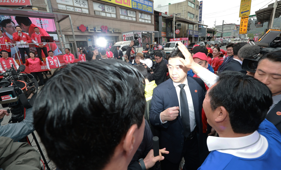정청래 더불어민주당 대표가 21일 충남 공주 산성시장에서 현장 유세를 마친 뒤 시장을 돌아보다 같은 시각 유세 중이던 장동혁 국민의힘 대표를 만나 손을 흔들며 인사하고 있다. 연합뉴스