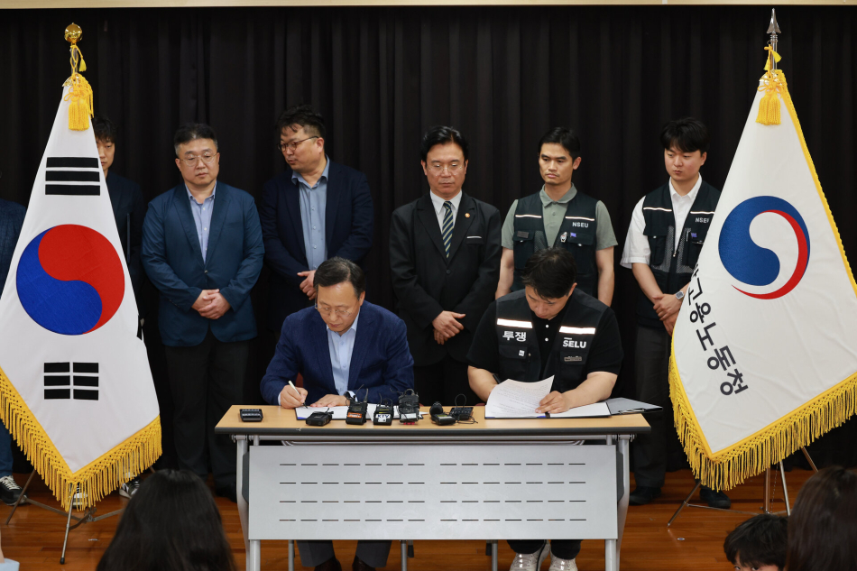 여명구 삼성전자 DS(디바이스솔루션·반도체 사업 담당) 피플팀장과 최승호 삼성그룹 초기업노동조합 삼성전자지부 위원장이 20일 경기도 수원시 장안구 경기고용노동청에서 임금협상을 마친 후 잠정 합의안에 서명하고 있다. 연합뉴스