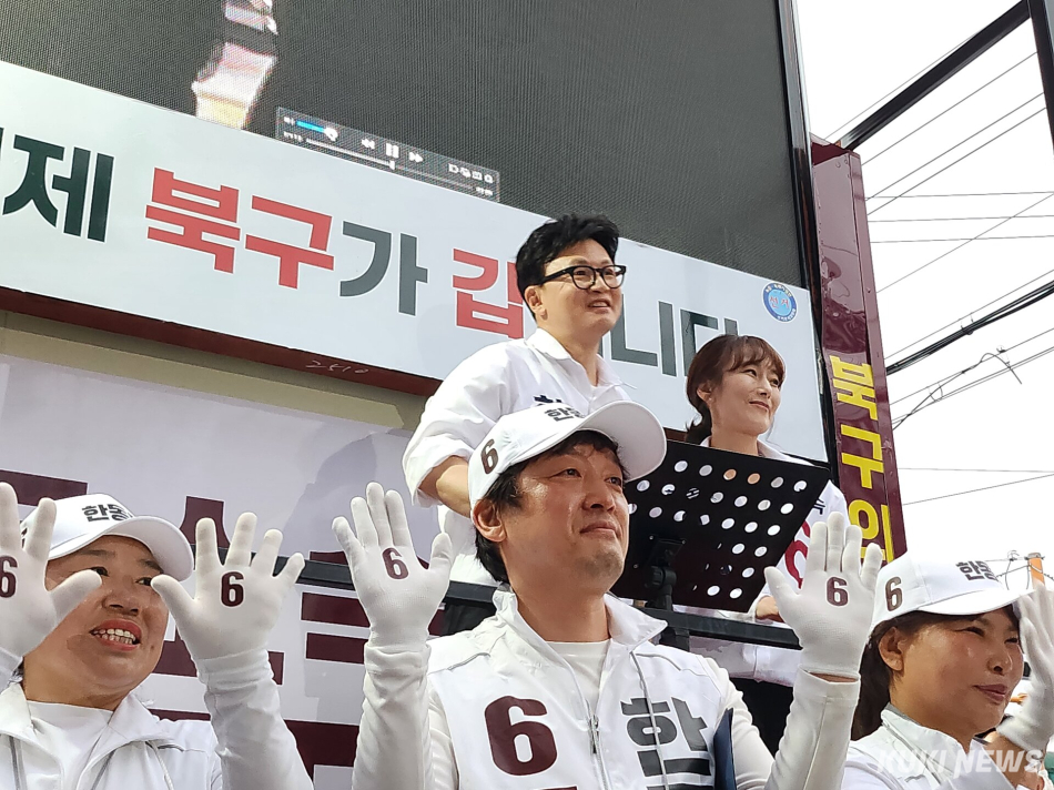 한동훈 무소속 부산 북갑 후보가 21일 부산 북구 구포시장 쌈지공원에서 열린 출정식에서 아내 진은정 변호사와 함께 인사를 하고 있다. 전재훈 기자