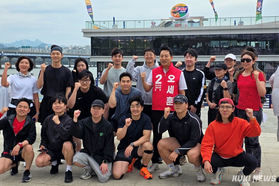오세훈 국민의힘 서울시장 후보가 21일 서울 영등포구 여의도 한강공원에서 달리기를 마친 사람들과 기념촬영을 하고 있다. 김건주 기자