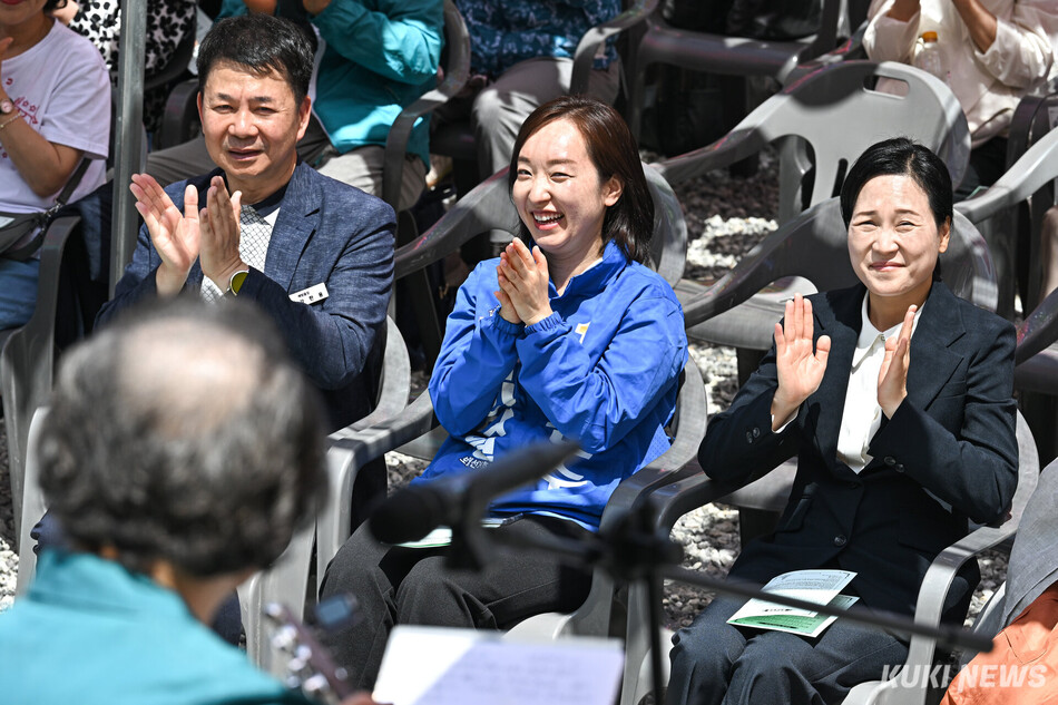 전은수 더불어민주당 아산을 국회의원 보궐선거 후보(가운데)와 김민경 국민의힘 후보가 24일 충남 아산 윤정사에서 축하 공연을 관람하고 있다.
