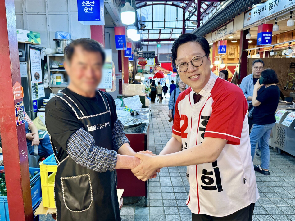 홍덕희 국민의힘 구로구청장 후보가 최근 서울 구로구의 한 시장에서 구민과 악수를 나누고 있다. 홍 후보 캠프 제공