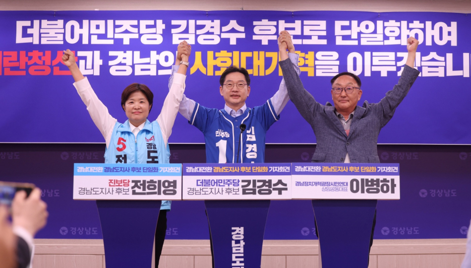 김경수 더불어민주당 경남지사 후보와 전희영 진보당 후보가 27일 경남도청 프레스센터에서 열린 ‘경남대전환 경남도지사 후보 단일화’ 긴급 기자회견에서 손을 들어 인사하고 있다. 두 정당은 김경수 후보로 단일화했다. 왼쪽부터 전 후보, 김 후보, 이병하 경남정치개혁광장시민연대 상임공동대표. 연합뉴스