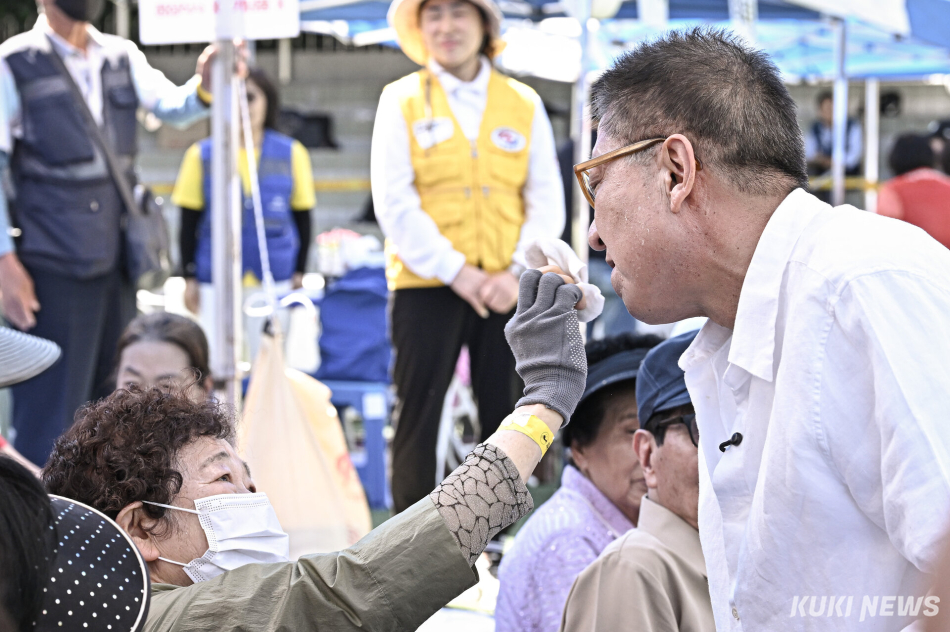 박형준 국민의힘 부산시장 후보가 30일 부산 해운대구 운봉초등학교에서 열린 파랑새어르신 체육대회에 참석한 가운데 한 어르신이 박 후보의 땀을 닦아주고 있다.