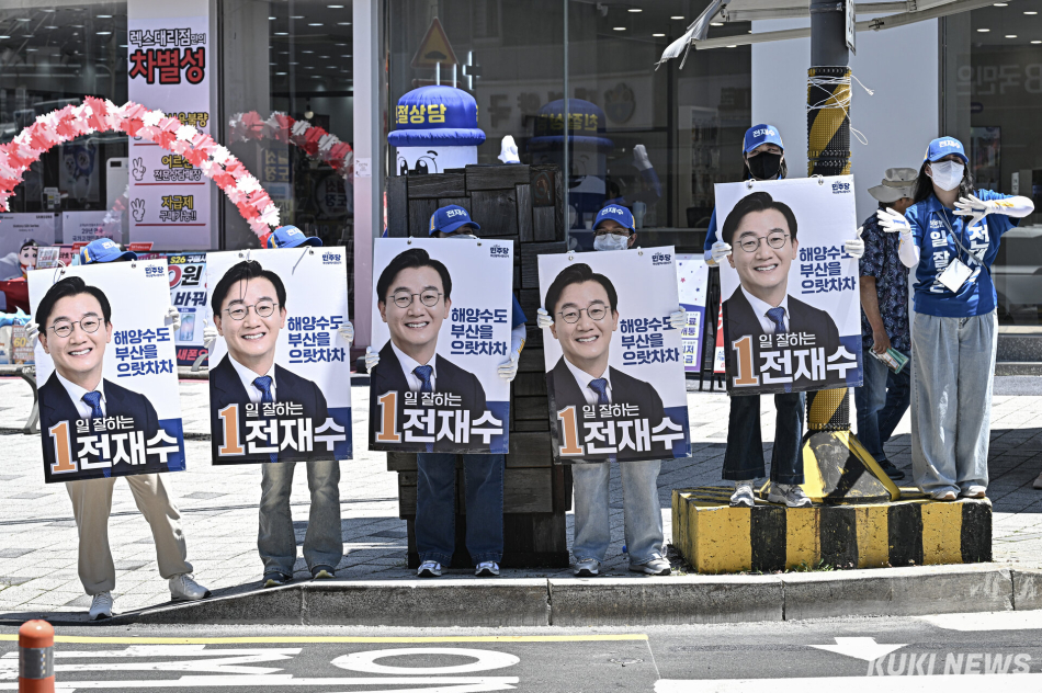 30일 부산 기장군 기장시장 인근에서 열린 전재수 더불어민주당 부산시장 후보 유세에서 선거운동원들이 피켓을 흔들고 있다.