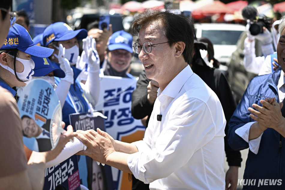 전재수 더불어민주당 부산시장 후보가 30일 부산 기장군 기장시장 인근 유세에서 선거운동원들과 인사하고 있다.