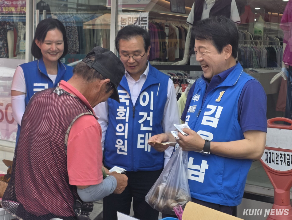 경기 평택을 국회의원 재선거에 출마하는 김용남 더불어민주당 후보가 안중시장 상인에게 안부를 물으며 과일을 사고 있다. 김미경 기자