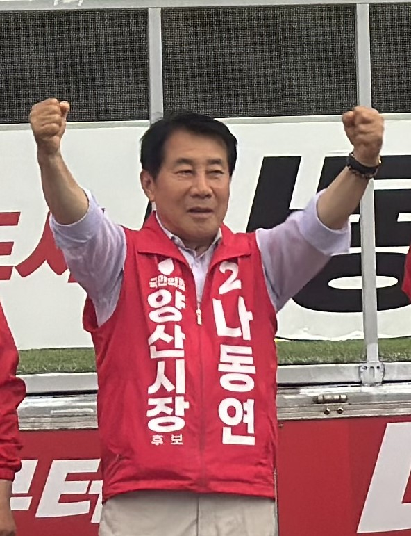 나동연 국민의힘 양산시장 후보가 유세차에서 연설을 하며 두손을 번쩍 들어보이고 있다. 나동연 후보 캠프 제공