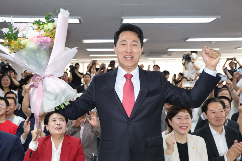 국민의힘 오세훈 서울시장 후보가 제9회 전국동시지방선거일 다음날인 4일 서울 종로구 대왕빌딩에 마련된 선거사무소에서 입장을 밝힌 뒤 꽃다발을 들어보이고 있다. 연합뉴스
