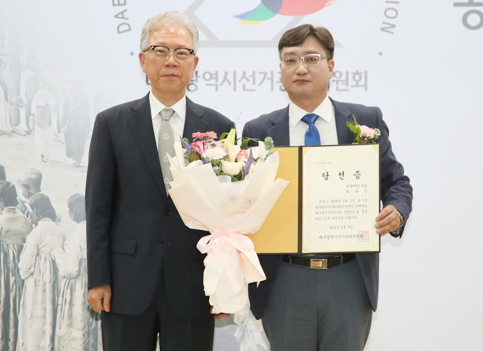 더불어민주당 최완식 대구 광역의원 비례대표 당선인(오른쪽)이 4일 오후 대구 서구 대구시선거관리위원회에서 열린 제9회 지방선거 당선증 교부식에서 당선증을 받은 뒤 대구시선관위 강동명 위원장과 기념 촬영을 하고 있다. 출처=연합뉴스