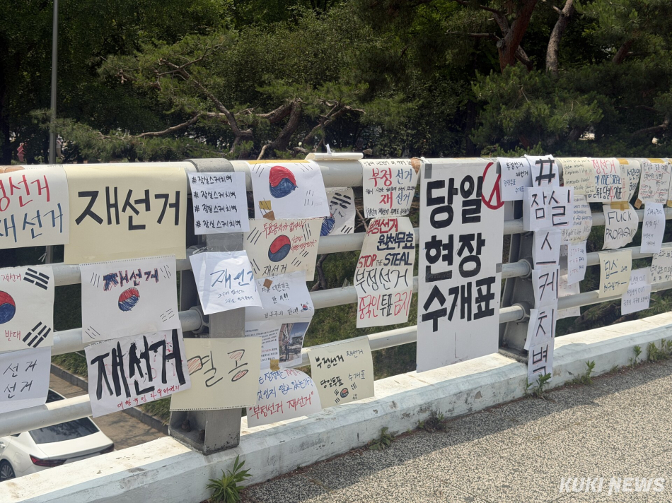 6·3 지방선거 투표용지 부족 사태를 규탄하며 재선거를 요구하는 ‘잠실 개표소 봉쇄 시위‘가 계속되고 있는 9일 서울 송파구 올림픽공원 핸드볼경기장에 손팻말이 붙어 있다. 유병민 기자