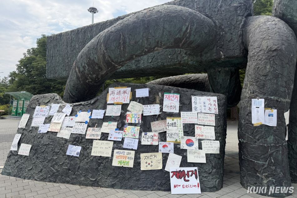 6·3 지방선거 투표용지 부족 사태를 규탄하며 재선거를 요구하는 ‘잠실 개표소 봉쇄 시위‘가 계속되고 있는 9일 서울 송파구 올림픽공원 핸드볼경기장에 손팻말이 붙어 있다. 유병민 기자
