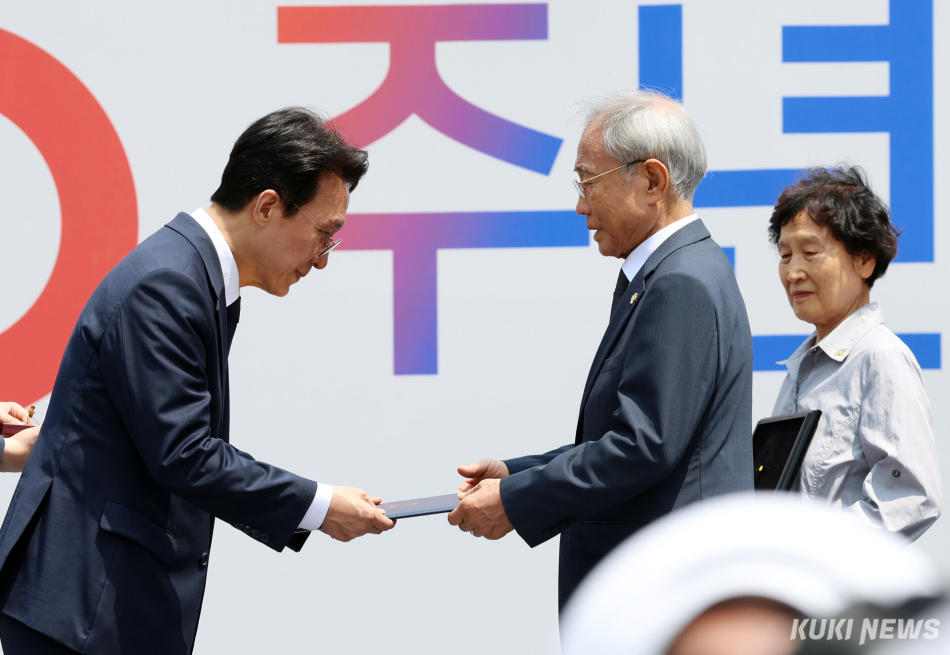김민석 국무총리가 10일 오전 서울 종로구 광화문광장에서 열린 제100주년 6·10 만세운동 기념식에서 고 손성엽 독립유공자 후손에게 포상을 전달하고 있다.