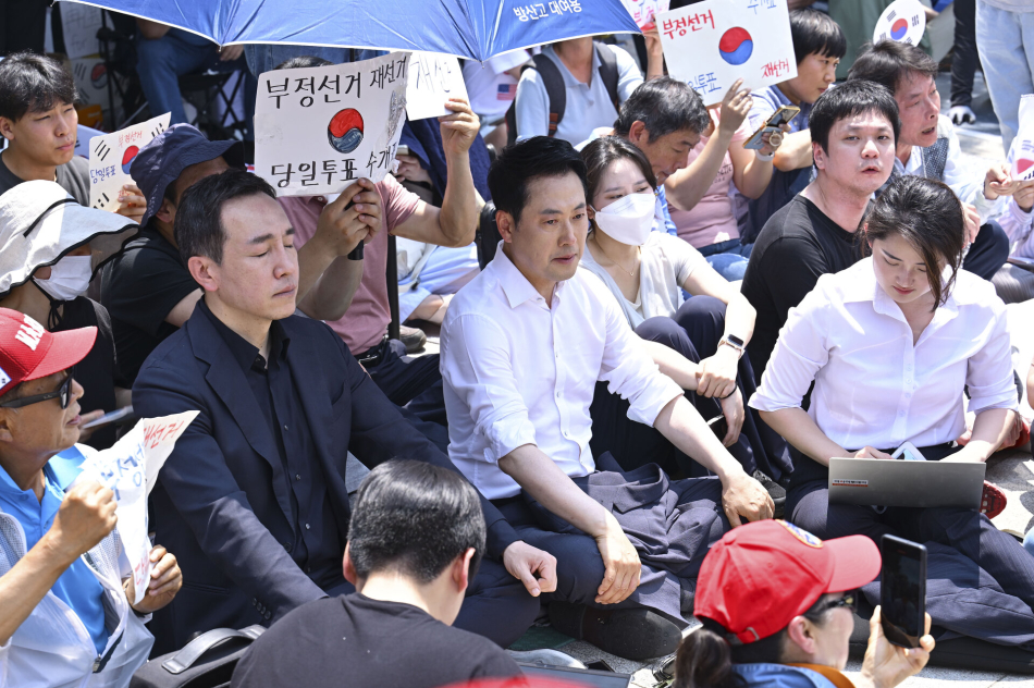 16일 서울 송파구 올림픽공원 핸드볼경기장 앞에 장동혁(가운데 오른쪽) 국민의힘 대표와 김민수 최고위원이 ‘개표소 봉쇄 시위‘ 참가자들과 함께 앉아 있다. 남동균 기자