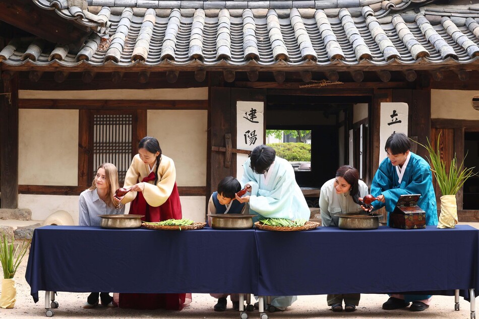 단오(음력 5월 5일)를 앞둔 17일 서울 종로구 국립민속박물관 오천댁 앞에서 열린 단오 세시행사에서 외국인 관광객이 창포물 머리감기 체험을 하고 있다.