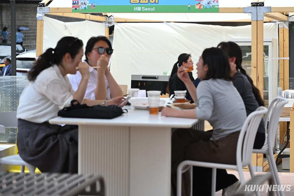 미식 팝업스토어 ‘로컬트립 맛;잇다’에 방문한 시민들이 17일 서울 중구 지역관광 안테나숍 옥상에 마련된 휴식 공간에서 구매한 음식을 맛보고 있다.
