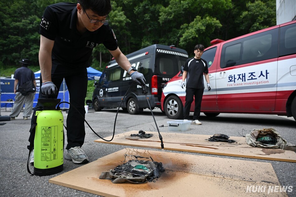 서울소방재난본부 관계자가 19일 서울 은평구 서울소방학교에서 진행된 보조배터리 보관 파우치 화재 적응성 실험이 끝난 후 불을 끄고 있다.