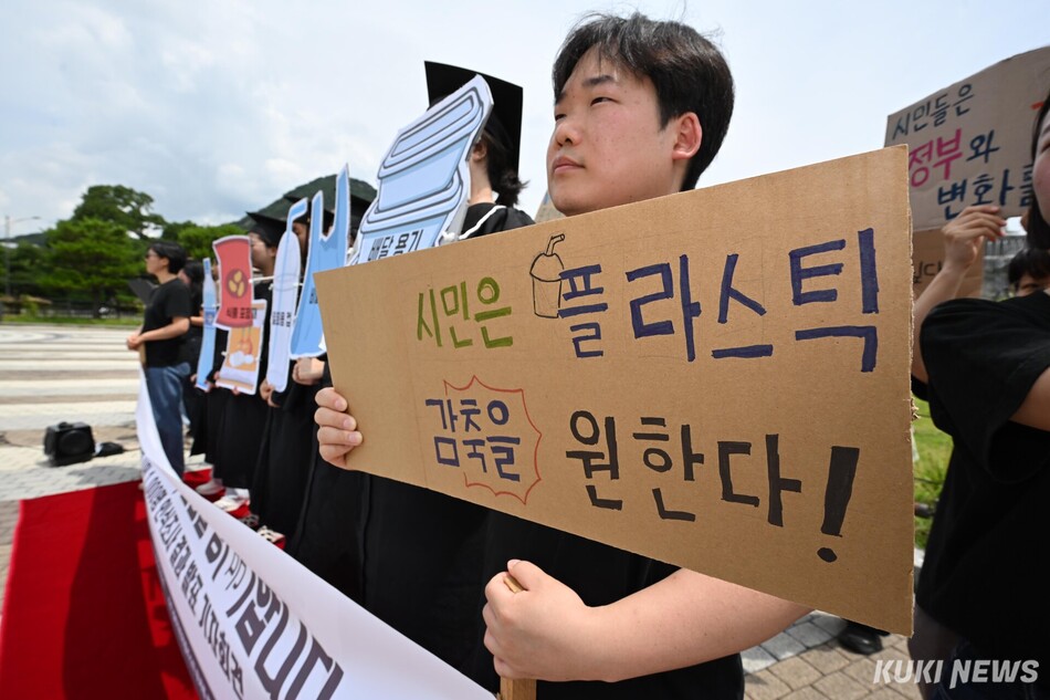 플뿌리연대 등 환경 단체 관계자들이 22일 서울 종로구 청와대 사랑채 앞에서 플라스틱 감축을 촉구하는 문구가 적힌 손피켓을 들고 있다.
