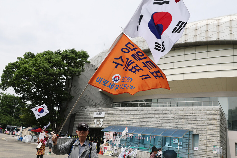 지난 22일 서울 송파구 올림픽공원 핸드볼경기장 앞에서 6·3 지방선거 투표용지 부족 사태 규탄 봉쇄 시위 참가자들이 재선거 및 당일투표 수개표 촉구 구호를 외치고 있다. 연합뉴스