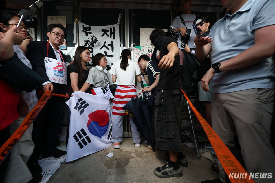 6·3지방선거 투표용지 부족 사태로 촉발된 잠실 개표소 봉쇄 시위가 12일째 이어진 16일 서울 송파구 올림픽공원 핸드볼경기장 개표소 앞에서 시민들이 국민의힘과 대한체육회 관계자들의 진입을 봉쇄하기 위해 문을 잡고 있다. 남동균 기자