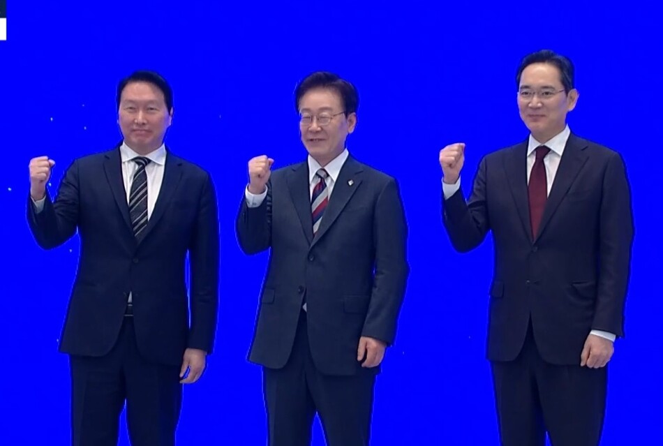 29일 이재명 대통령 주재 ‘대한민국 대도약 3대 메가프로젝트 국민보고회’에서 최태원 SK그룹 회장과 이재용 삼성전자 회장이 국가와 민간 기업이 합심하자는 의미로 ‘화이팅‘ 포즈를 취하고 있다. 생방송 캡처