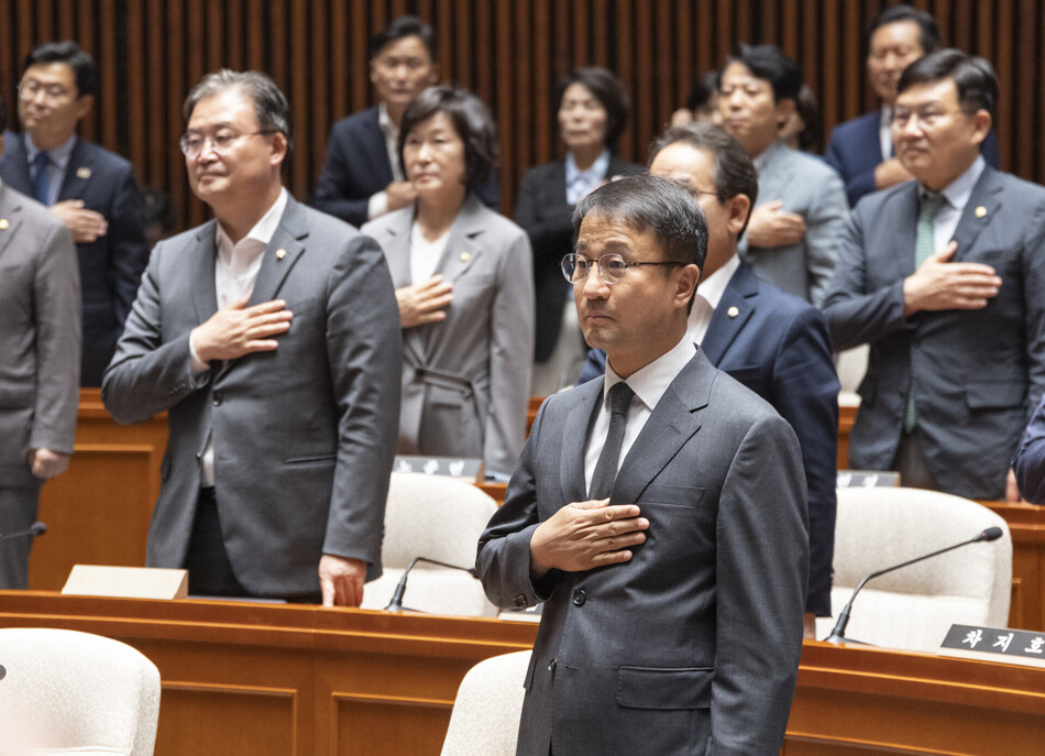 더불어민주당 한병도 당 대표 직무대행 및 원내대표를 비롯한 의원들이 29일 국회에서 열린 의원총회서 국기에 경례하고 있다.