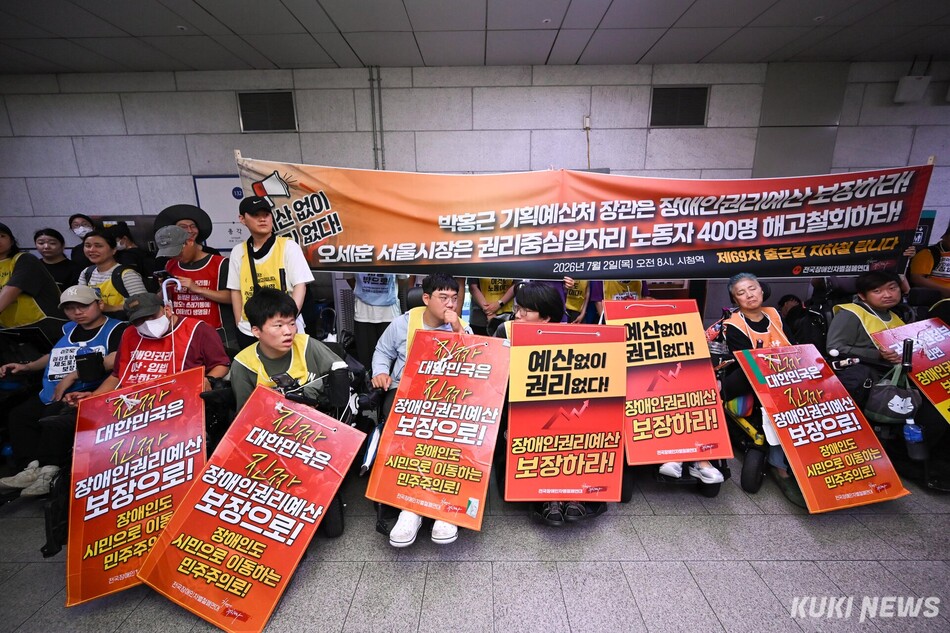 전국장애인차별철폐연대 활동가들이 2일 서울 중구 시청역 승강장에서 손팻말을 들고 있다. 임은재 기자