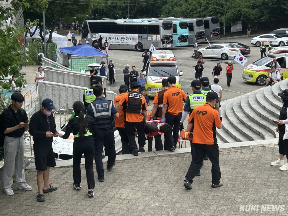 국조특위 현장조사를 앞두고 올림픽공원 핸드볼경기장 앞에서 일부 충돌이 발생, 한 참가자가 들것에 실려나가고 있다. 유정민 인턴 기자