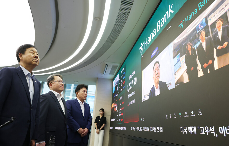 구윤철 부총리 겸 재정경제부 장관(왼쪽부터), 권민수 한국은행 부총재보, 함영주 하나금융 회장이 24시간 외환시장 개장 첫날인 6일 서울 중구 하나은행 본점 딜링룸을 방문해 삼성전자 재경팀과 하나은행 런던지점 직원들과 화상으로 대화하고 있다. 공동취재.