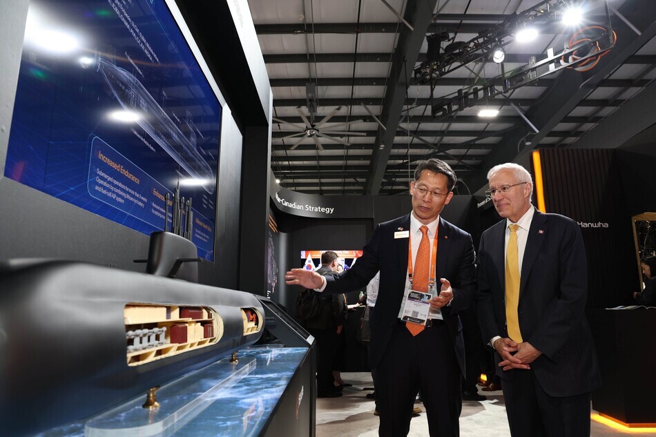 캐나다 오타와에서 열린 ‘CANSEC 2026’ 전시회 내 한화오션 부스에서 정승균 한화오션 특수선해외사업단장 부사장(왼쪽)이 빅터 피델리 온타리오주 경제개발부 장관에게 최신예 잠수함인 KSS-III 모델을 소개하고 있다. 한화오션 제공