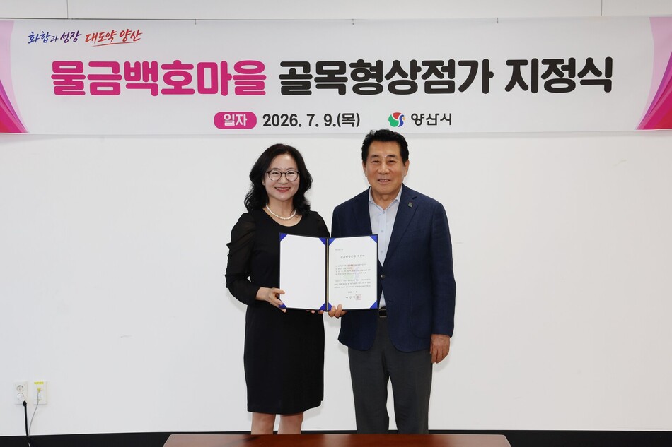 나동연 양산시장이 9일 김순희 물금 백호마을 상인회장에게 골목형상점가 지정서를 전달하고 있다. 양산시 제공