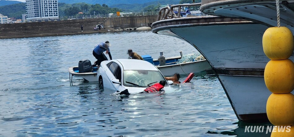 16일 오후 양양군 현남면 동산항 앞 해상으로 추락한 차량에서 해양경찰이 60대 운전자를 구조하고 있다. 강릉해양경찰서 제공