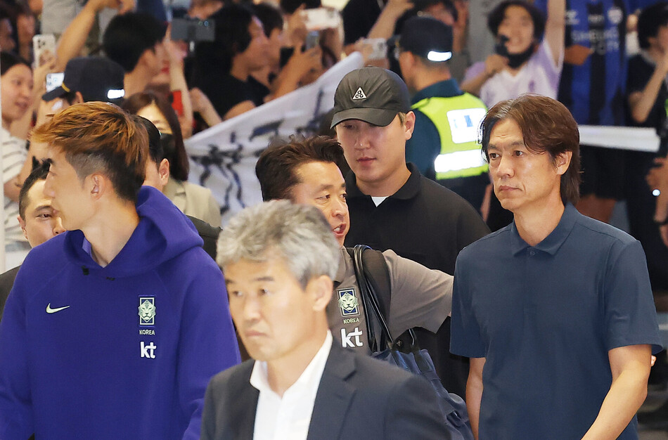 홍명보 전 감독이 지난 6월30일 인천국제공항 제2여객터미널을 통해 입국하며 항의하는 팬들의 현수막을 지나치고 있다.