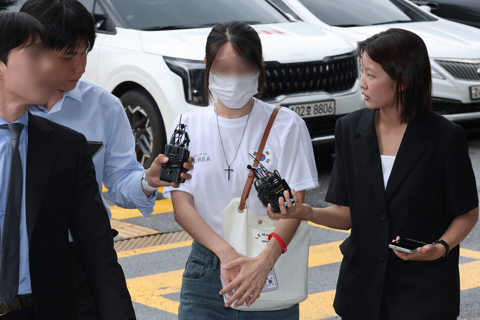 6·3 지방선거 개표소로 사용된 올림픽공원 핸드볼경기장 문 앞에서 체육단체 직원들의 장내 사무실 진입을 막아 업무 방해 혐의를 받는 30대 여성 A씨가 지난 10일 서울 송파경찰서에서 조사받기 위해 출석하고 있다. 연합뉴스